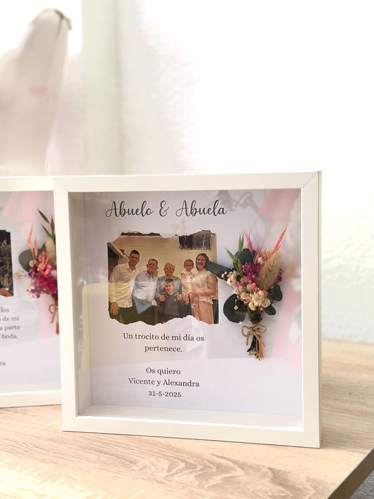 Cuadro con texto, flores preservadas y fotografía.